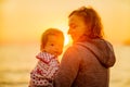 Tourism. Camping. Mom and daughter admire the sunset on the shore of the winter sea. Beautiful sunset in winter. Parent and child.