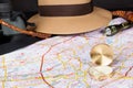 Tourism concept. Compass on city map with flashlight, fedora hat, bullwhip and binocular in the background. Selective focus Royalty Free Stock Photo
