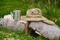 Tourism day. tin mug and hat with wide brim sun protective lie on a log in the forest Royalty Free Stock Photo