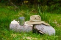 Tourism day. metal mug and tourist hat with fields lie on a log in the forest Royalty Free Stock Photo