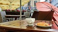 Tourism in Europa Street cafe table with cup of coffee umbrella   on chair and sparrow sit on table eating sweet cake travel to Eu Royalty Free Stock Photo