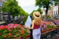 Tourism in Holland. Back view of beautiful fashion girl between flower pots in The Hague, Netherlands