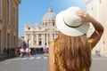 Tourism in Italy. Back view of young tourist woman walks along Via della Conciliazione street in Rome with St Peter Basilica and Royalty Free Stock Photo