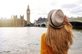 Tourism in London. Back view of tourist woman enjoying sight of Westminster palace and bridge on Thames with famous Big Ben tower Royalty Free Stock Photo