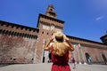 Tourism in Milan, Italy. Young tourist woman in front of Sforza Castle main entrance, Milan, Italy