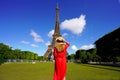 Tourism in Paris. Back view of young woman looks at the Eiffel Tower from Champ de Mars in Paris, France