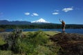 Tourism in Pucon Man tourist standing with hand up posing for photo with view of snow capped Villarrica volcano Royalty Free Stock Photo