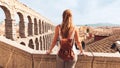 rear view of woman tourist enjoying view of Roman aqueduct on plaza del Azoguejo in Spain Royalty Free Stock Photo