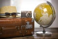 Tourism and travel concept. Globe and vintage suitcase with summer hat, sunglasses photo camera on wooden table Royalty Free Stock Photo