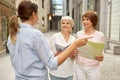 Passerby showing direction to senior women in city