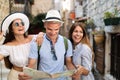 Smiling gorup of friends with map. Tourism, travel, leisure, holidays and friendship concept