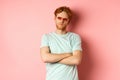 Tourism and vacation concept. Sassy redhead guy in sunglasses, cross arms on chest and looking serious at camera Royalty Free Stock Photo