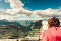 Tourist looking through binoculars in mountains, Norway