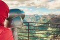 Tourist looking through binoculars in mountains, Norway