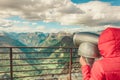 Tourist looking through binoculars in mountains, Norway