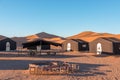 Tourist accommodation campsite in the desert with big sand dunes in the background