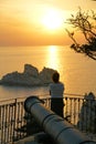 A tourist admires the view of a sunset from the monastery of the Virgin Mary at sunset