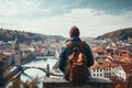 Tourist admiring beautiful view of small European town. Adventurous young person with backpack. Hiking and trekking on a nature