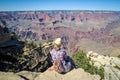 Tourist admiring multicoloured rocks with dozens of layers in Grand Canyon