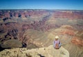 Tourist admiring multicoloured rocks with dozens of layers in Grand Canyon