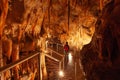 Tourist admiring the stalactites in limestone cave.