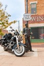 Tourist arrives on Harley Davidson motorcycle at famous Winslow Arizona br statue of Eagles ban-member Glenn Frey under sign