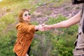 Tourist asian woman getting help to friend climb a rock,Helping hands,Overcoming obstacle concept Royalty Free Stock Photo