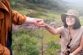 Tourist asian women getting help to friend climb a rock,Helping hands,Overcoming obstacle concept Royalty Free Stock Photo