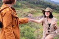 Tourist asian woman getting help to friend climb a rock,Helping hands,Overcoming obstacle concept Royalty Free Stock Photo