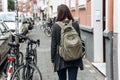 Tourist with a backpack is looking for booked online accommodation in an unfamiliar city.