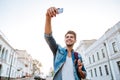 Tourist with backpack making selfies on beautiful modern buildings Royalty Free Stock Photo