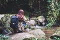 A tourist with backpack shooting video of the waterfall in the forest by an action camera Royalty Free Stock Photo