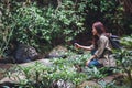 A tourist with backpack shooting video of the waterfall in the forest by an action camera Royalty Free Stock Photo