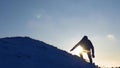 Tourist with a backpack travels on snow-capped mountains. climber gently descends from snowy mountain, slides down in Royalty Free Stock Photo