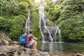 Backpacker looking at waterfall in Bali, tourism
