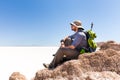 Tourist backpacker sitting mountain peak, above salt desert, Bol