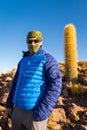 Tourist backpacker standing mountain huge cactus, Salar De Uyuni, Bolivia.