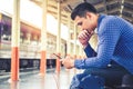 Tourist backpacker using mobile phone to travel at train station