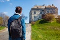Tourist backpacker visiting Olesko Castle in spring. Trip to Western Ukraine. Traveler enjoys landscape
