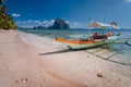 Tourist banca boat on beach ready for island hopping with beautiful scenery of surreal Pinagbuyutan island in background Royalty Free Stock Photo
