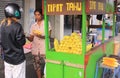 Tourist bargaining with steamed corn seller in the street, in Bali. Royalty Free Stock Photo