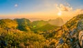 A tourist with beautiful mountain peaks topped with vivid sky, cloud and blast horizon sun, and decorated with camera flares Royalty Free Stock Photo