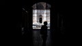 tourist from behind in the arcades in Piazza Maggiore in Bologna with the Unfinished Church in the background. Italy