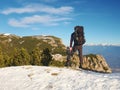 Tourist with big backpack and snowshoes standing on rocky view point and watching into rocky mountains. National park Alpine park. Royalty Free Stock Photo