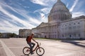 Tourist on a bike pause to look at the Capitol Building in Washington DC, USA