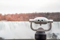 Tourist Binocular with a Waterfall in Background at Sunset