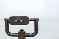 Tourist binoculars on a pier directed into the foggy sea in cloudy weather Royalty Free Stock Photo