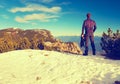 Tourist in black is standing on rocky view point and watching into misty rocky mountains. Fogy winter morning in Alps.. Royalty Free Stock Photo