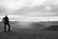 Tourist in black with white cap is standing above Alpine valey.. National park Alps park in Italy.