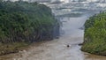 A tourist boat rushes along a stormy river. Iguazu Falls